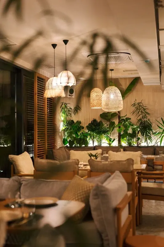 Plants and lamps between the tables